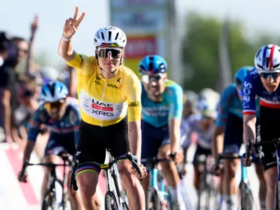 Winner Tadej Pogacar, left, from Slovenia, celebrates ahead of second placed Dorion Godon, right, from France, to win the second stage, a 173,1 km race between Rue and Vucherens, of the 79th Tour de Romandie UCI World Tour Cycling race, in Vuillens, Switzerland, Thursday, April 30, 2026. (Laurent Gillieron/Keystone via AP)
