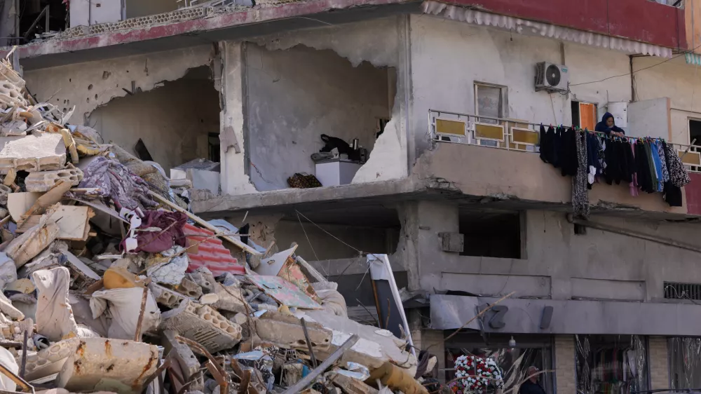 A woman hangs laundry in her damaged apartment after returning home with her family in the southern port city of Tyre, Lebanon, Thursday, April 30, 2026. (AP Photo/Hussein Malla)