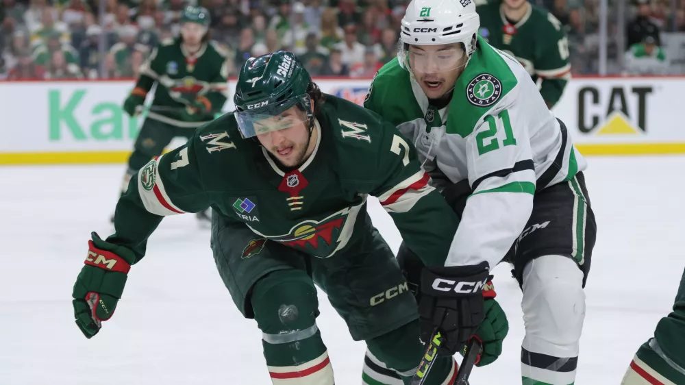 Minnesota Wild defenseman Brock Faber (7) and Dallas Stars left wing Jason Robertson (21) battle for position during the second period of Game 6 in the first round of the NHL hockey Stanley Cup playoff series Thursday, April 30, 2026, in St. Paul, Minn. (AP Photo/Bailey Hillesheim)