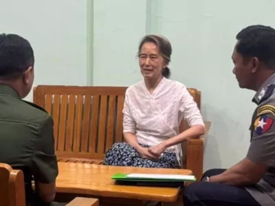 In this updated photo provided on April 30, 2026, by Myanmar Military True News Information Team, Myanmar's former leader Aung San Suu Kyi, center, talks with officials, in undisclosed location in Myanmar. (Myanmar Military True News Information Team via AP)