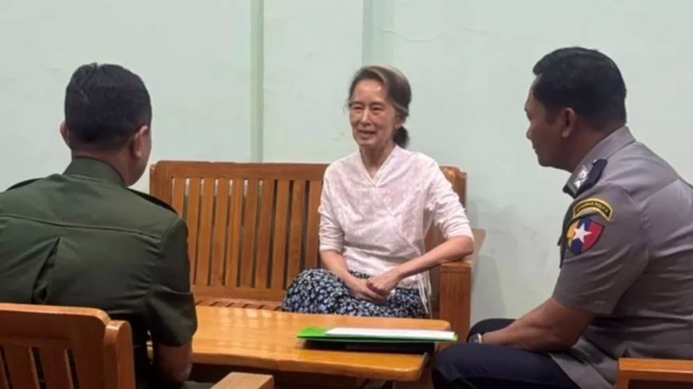 In this updated photo provided on April 30, 2026, by Myanmar Military True News Information Team, Myanmar's former leader Aung San Suu Kyi, center, talks with officials, in undisclosed location in Myanmar. (Myanmar Military True News Information Team via AP)
