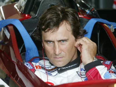 FILE PHOTO: Italian driver Alex Zanardi uses his ear sticks before sitting in the cockpit of his specially modified car at the Eurospeedway Lausitzring circuit in the eastern German town of Klettwitz May 11, 2003, before the German 500 CART race. Zanardi returned on Sunday to the race track in Germany where he lost both legs in a crash two years ago. REUTERS/Fabrizio Bensch/File Photo