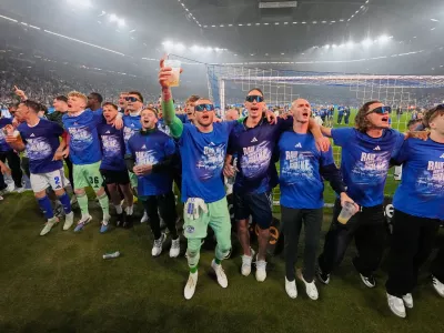 Schalke's keeper Loris Karius, center, celebrates teammates after FC Schalke 04 secured promotion to the German Bundesliga by winning the Bundesliga 2 match against Fortuna D&uuml;sseldorf at the arena in Gelsenkirchen, Germany, Saturday, May 2, 2026. (AP Photo/Martin Meissner)