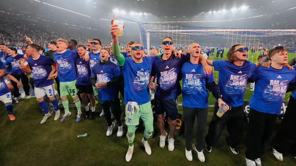 Schalke's keeper Loris Karius, center, celebrates teammates after FC Schalke 04 secured promotion to the German Bundesliga by winning the Bundesliga 2 match against Fortuna D&uuml;sseldorf at the arena in Gelsenkirchen, Germany, Saturday, May 2, 2026. (AP Photo/Martin Meissner)