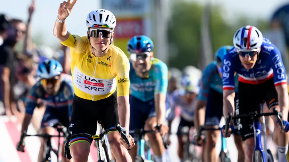 Winner Tadej Pogacar, left, from Slovenia, celebrates ahead of second placed Dorion Godon, right, from France, to win the second stage, a 173,1 km race between Rue and Vucherens, of the 79th Tour de Romandie UCI World Tour Cycling race, in Vuillens, Switzerland, Thursday, April 30, 2026. (Laurent Gillieron/Keystone via AP)
