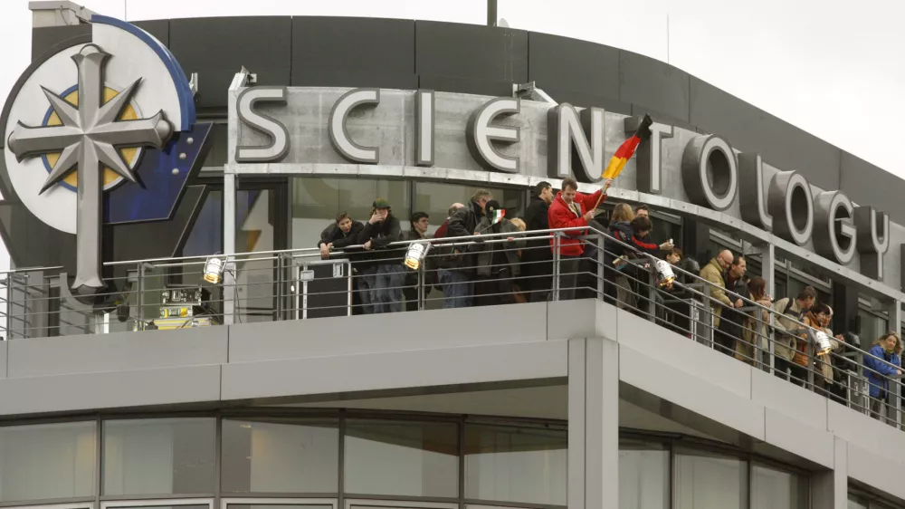 People stand on a balcony of the new office of the Scientology Church in Berlin January 13, 2007.       REUTERS/Arnd Wiegmann  (GERMANY)