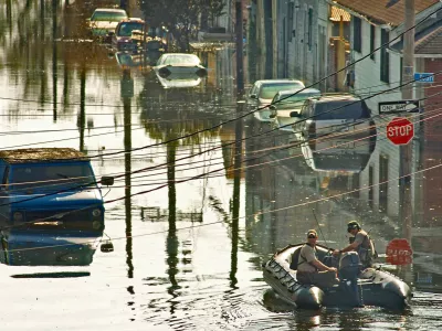 Two emergency personnel slowly cruise up a flooded street in New Orleans on Sunday, Sept. 4, 2005, six days after Hurricane Katrina devastated much of the gulf coast. Some residents have decided to remain, even as they are surrounded by floodwaters. (AP Photo/The Baltimore Sun, Karl Merton Ferron)