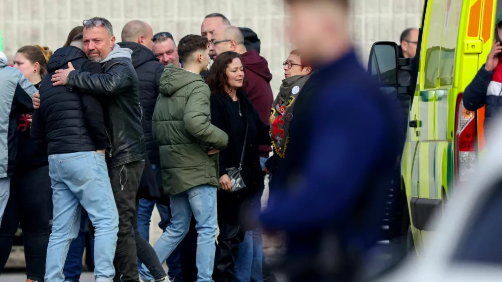 People react after a vehicle drove into a group of Belgian carnival performers who were preparing for a parade in the village of Strepy-Bracquegnies, Belgium March 20, 2022. REUTERS/Johanna Geron