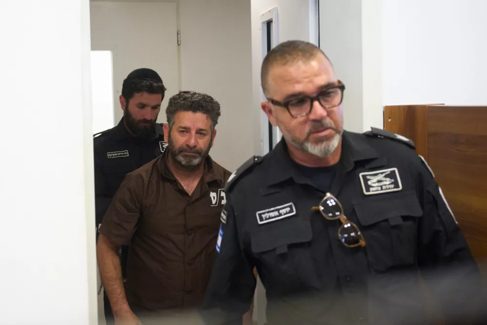 Palestinian-Spanish activist Saif Abukeshek, center, a member of the Global Sumud Flotilla, is escorted by prison service guards to a hearing at the District Court in Ashkelon, Israel, on Sunday, May 3, 2026. (AP Photo/Ohad Zwigenberg)