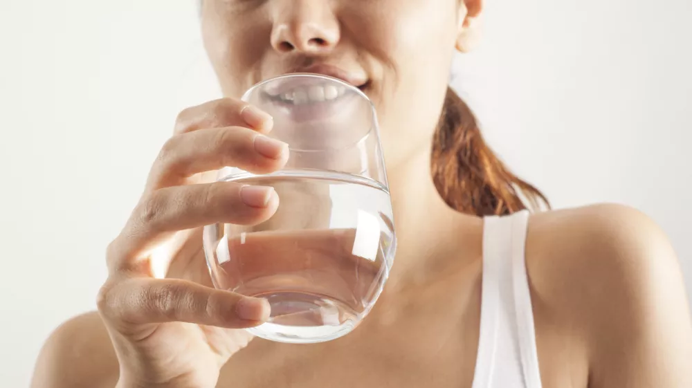 Young woman drinking glass of water