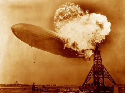 Hindenburg disaster, coloured image. View of the German airship Hindenburg (LZ 129) on fire over Naval Air Station (NAS) Lakehurst, New Jersey, USA, on 6th May 1937. This airship is famous for the Hindenburg disaster of 6th May 1937, when it caught fire and was destroyed during its attempt to dock with its mooring mast at NAS Lakehurst. Of the 97 crew and passengers on board 35 were killed, along with one member of the ground crew. The balloon was filled with hydrogen, a highly flammable gas. The cause of the accident has never been established but the disaster destroyed public confidence and marked the abrupt end of the airship era. Here the ships water ballast tanks (black dots, lower centre-left) can be seen falling.,Image: 270936545, License: Rights-managed, Restrictions:, Model Release: no