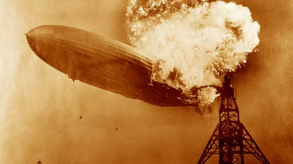 Hindenburg disaster, coloured image. View of the German airship Hindenburg (LZ 129) on fire over Naval Air Station (NAS) Lakehurst, New Jersey, USA, on 6th May 1937. This airship is famous for the Hindenburg disaster of 6th May 1937, when it caught fire and was destroyed during its attempt to dock with its mooring mast at NAS Lakehurst. Of the 97 crew and passengers on board 35 were killed, along with one member of the ground crew. The balloon was filled with hydrogen, a highly flammable gas. The cause of the accident has never been established but the disaster destroyed public confidence and marked the abrupt end of the airship era. Here the ships water ballast tanks (black dots, lower centre-left) can be seen falling.,Image: 270936545, License: Rights-managed, Restrictions:, Model Release: no