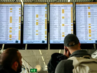 People look at departures screens showing delayed and cancelled flights at Amsterdam Airport Schiphol, as snowfall causes disruptions to air, rail and road traffic in the Netherlands, in Schiphol, Netherlands January 6, 2026. REUTERS/Piroschka van de Wouw / Foto: Piroschka Van De Wouw