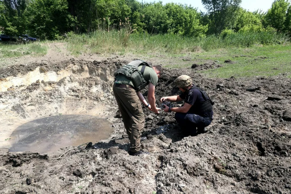 Forensic experts work at the crater of a projectile during a response effort to a Russian S-300 missile strike on a printing company in Kharkiv, northeastern Ukraine, May 23, 2024. As reported, on the morning of May 23, Russian troops attacked the Kharkiv region. In Kharkiv, seven people were killed and 20 others were injured at a printing company. A large-scale fire broke out. In Liubotyn, eight people were injured. The Ukrainian Railways said that their facilities in Kharkiv and the region had been hit, and six employees had been injured.,Image: 875983294, License: Rights-managed, Restrictions:, Model Release: no
