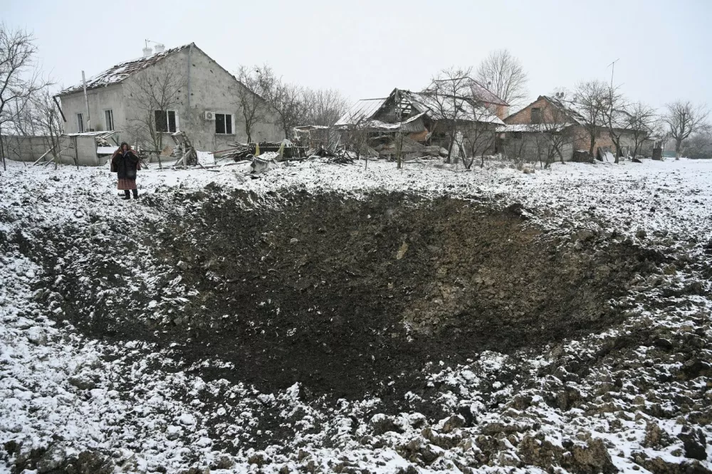 Yaroslava Sukach, 77, a local resident whose house was destroyed stands next to a crater following a missile strike on the village of Sknyliv, some 60km from Lviv, on January 15, 2025, amid the Russian invasion of Ukraine. Russia launched dozens of missiles and drones at the Ukrainian energy sector, Kyiv said on January 15, ramping up a months-long bombing campaign at a precarious moment of the war for Ukraine. The Ukrainian air force said Russia had deployed 43 cruise and ballistic missiles and 74 attack drones in the overnight barrage that appeared to have targeted sites mainly in western Ukraine.,Image: 953897239, License: Rights-managed, Restrictions:, Model Release: no