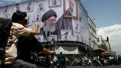 People ride motorcycles near a billboard featuring an image of the late Supreme Leader of Iran, Ayatollah Ali Khamenei, in Tehran, Iran, May 6, 2026. Majid Asgaripour/WANA (West Asia News Agency) via REUTERS ATTENTION EDITORS - THIS PICTURE WAS PROVIDED BY A THIRD PARTY   TPX IMAGES OF THE DAY