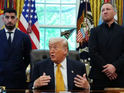 President Donald Trump speaks as Ilia Topuria, left, and Justin Gaethje listen during a meeting with UFC fighters, Wednesday, May 6, 2026, in the Oval Office of the White House, in Washington. (AP Photo/Jacquelyn Martin)
