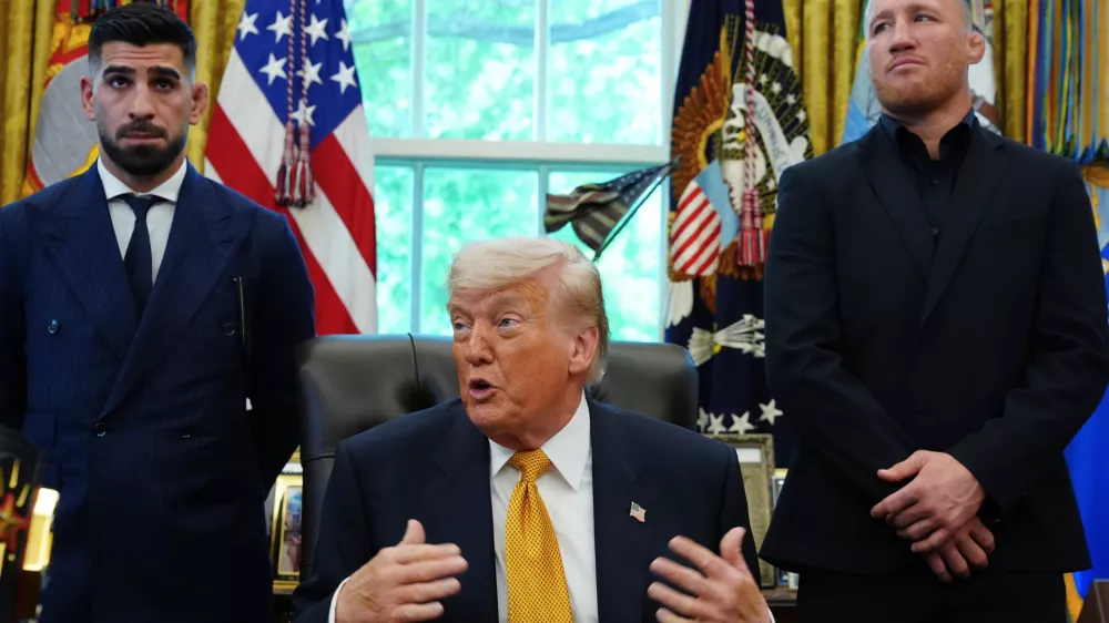 President Donald Trump speaks as Ilia Topuria, left, and Justin Gaethje listen during a meeting with UFC fighters, Wednesday, May 6, 2026, in the Oval Office of the White House, in Washington. (AP Photo/Jacquelyn Martin)