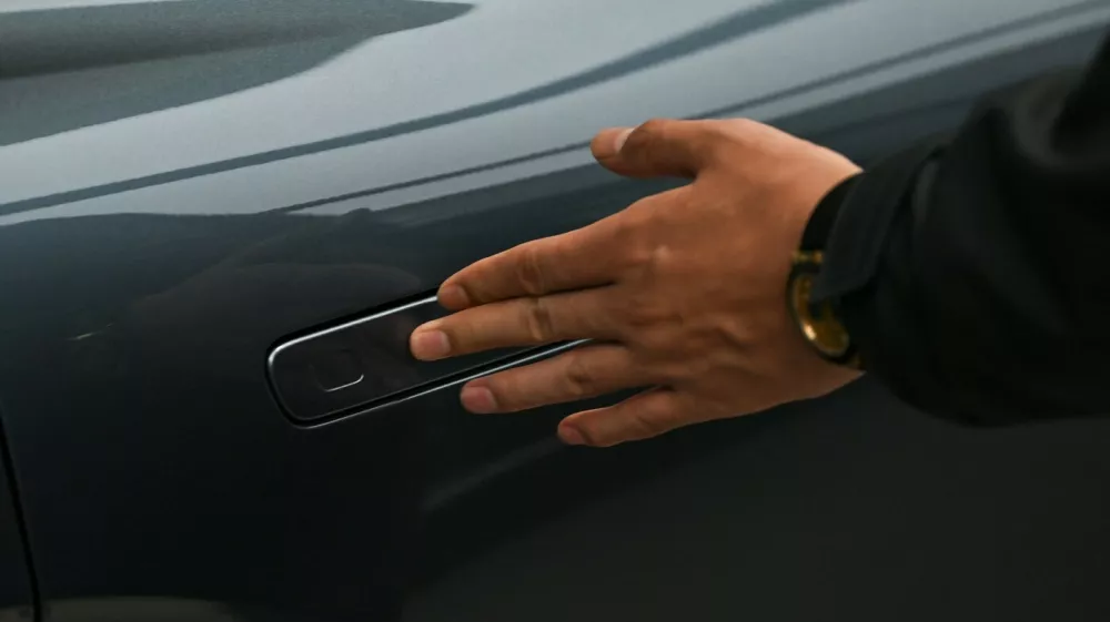 A man opens the door for a Zeekr X7 electric vehicle at a showroom in Beijing on February 3, 2026. China will ban hidden door handles on cars sold in the country from next year, phasing out the minimalist design popularised by Tesla over safety concerns.,Image: 1071617304, License: Rights-managed, Restrictions:, Model Release: no
