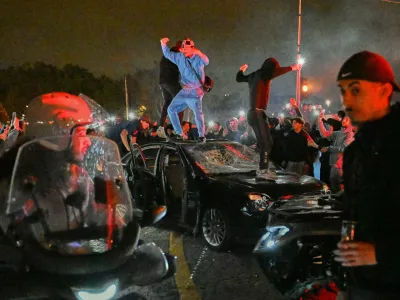 People smash a car as they celebrate Paris Saint-Germain's Champions League semifinal victory over Bayern Munich at Place de la Concorde in Paris, Thursday, May 7, 2026. (AP Photo/Emma Da Silva)