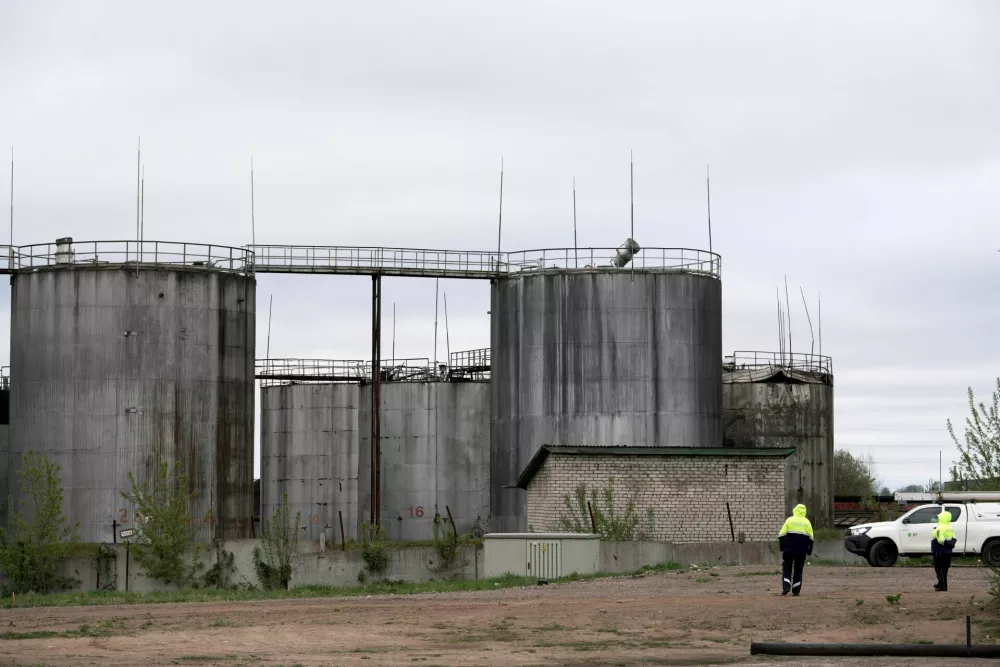 Police officers stand at the site of damage after drones crashed at a storage facility in Rezekne, Latvia, May 7, 2026. REUTERS/Janis Laizans
