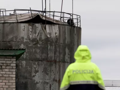 Police officer looks at damage to an oil tank after drones crashed at a storage facility in Rezekne, Latvia, May 7, 2026. REUTERS/Janis Laizans