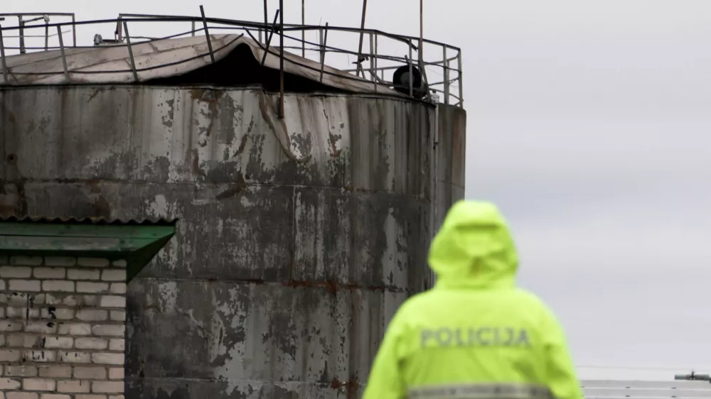 Police officer looks at damage to an oil tank after drones crashed at a storage facility in Rezekne, Latvia, May 7, 2026. REUTERS/Janis Laizans