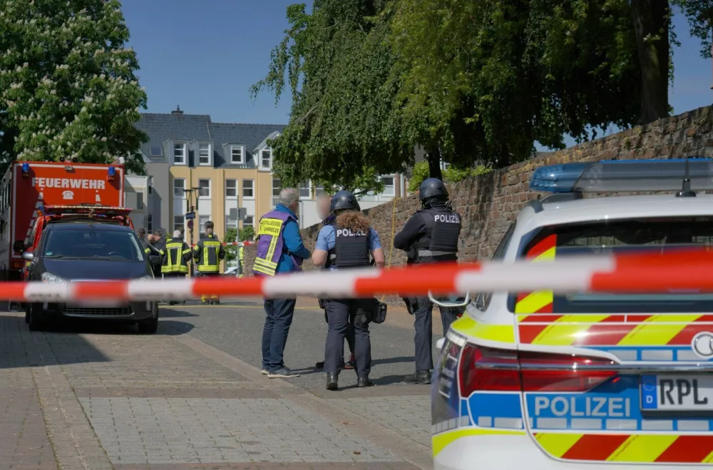 08 May 2026, Rhineland-Palatinate, Sinzig: Police officers and police vehicles stand behind barrier tape. According to initial police reports, a hostage situation has occurred at a bank branch in Sinzig, Rhineland-Palatinate. The emergency services are on the scene with a large contingent in the Ahrweiler district. Photo: Sascha Ditscher/dpa - ATTENTION: Civilian person and identification number(s) have been pixelated for legal reasons,Image: 1097317297, License: Rights-managed, Restrictions: GERMANY OUT, Model Release: no