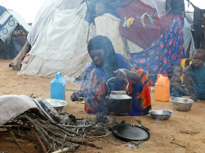 An internally displaced woman prepares breakfast outside their makeshift shelter during a visit by World Food Programme's Assistant Executive Director for Programme Operations, Matthew Hollingworth (not in the photo), to assess the knock on effects from the escalation in the Middle East, alongside drought and sharp cuts in humanitarian funding that are worsening hunger, in Kahda district of Mogadishu, Somalia May 7, 2026. REUTERS/Feisal Omar