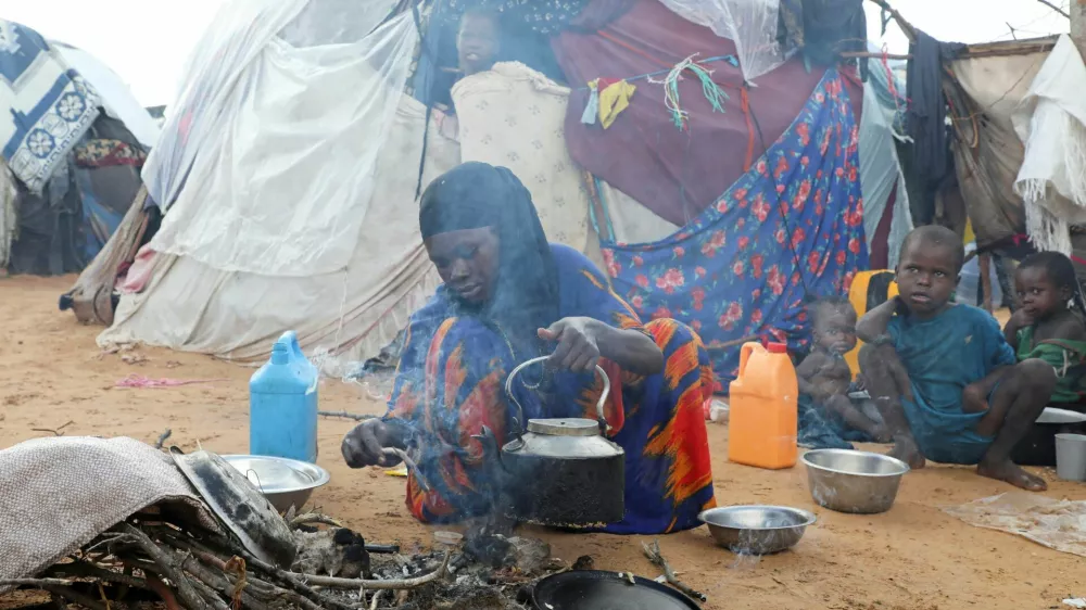 An internally displaced woman prepares breakfast outside their makeshift shelter during a visit by World Food Programme's Assistant Executive Director for Programme Operations, Matthew Hollingworth (not in the photo), to assess the knock on effects from the escalation in the Middle East, alongside drought and sharp cuts in humanitarian funding that are worsening hunger, in Kahda district of Mogadishu, Somalia May 7, 2026. REUTERS/Feisal Omar