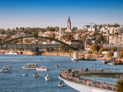 1 June 2025, Belgrade, Serbia: Modern pedestrian bridge over Sava River with tourists walking and enjoying the view
