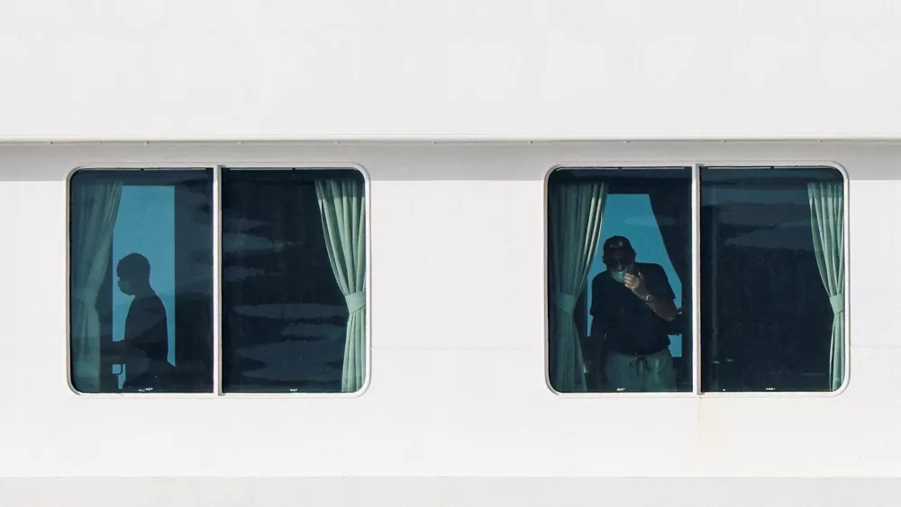 People aboard the cruise ship MV Hondius, which is affected by a hantavirus outbreak, at the port of Granadilla de Abona in Tenerife, Spain, May 10, 2026. REUTERS/Hannah McKay