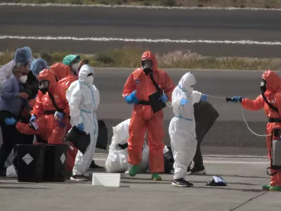 Passengers are sprayed with disinfectant by Spanish government officials before boarding a plane after disembarking from the hantavirus-stricken cruise ship MV Hondius at Tenerife airport in the Canary Islands, Spain, Sunday, May 10, 2026. (AP Photo/Arturo Rodriguez)