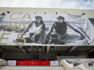 Workers set up a giant canvas of the official poster featuring actors Geena Davis and Susan Sarandon from Ridley Scott's road movie "Thelma & Louise" on the facade of the Festival palace before the start of the 79th Cannes Film Festival in Cannes, France, May 10, 2026. REUTERS/ Marko Djurica