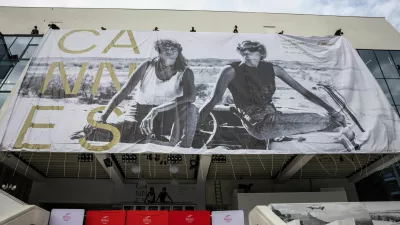 Workers set up a giant canvas of the official poster featuring actors Geena Davis and Susan Sarandon from Ridley Scott's road movie "Thelma & Louise" on the facade of the Festival palace before the start of the 79th Cannes Film Festival in Cannes, France, May 10, 2026. REUTERS/ Marko Djurica