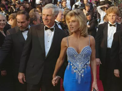 FILE PHOTO: Actor Jane Fonda and media mogul Ted Turner hold hands as they arrive at the Academy Awards in Los Angeles, California, U.S., March 26, 1990. REUTERS/Lee Celano/File Photo DISCLAIMER: The image is presented in its original, uncropped, and untoned state. Due to the age and historical nature of the image, we recommend verifying all associated metadata, which was transferred from the index stored by the Bettmann Archives, and may be truncated.