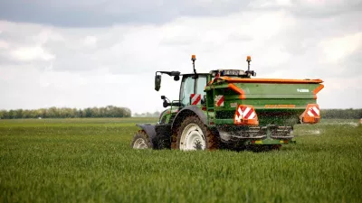 A French cereal farmer drives his tractor with a spinning-disc that spreads nitrogen fertilizer white pellets on a wheat field in Larchant, France, May 7, 2026. REUTERS/Alice Sacco