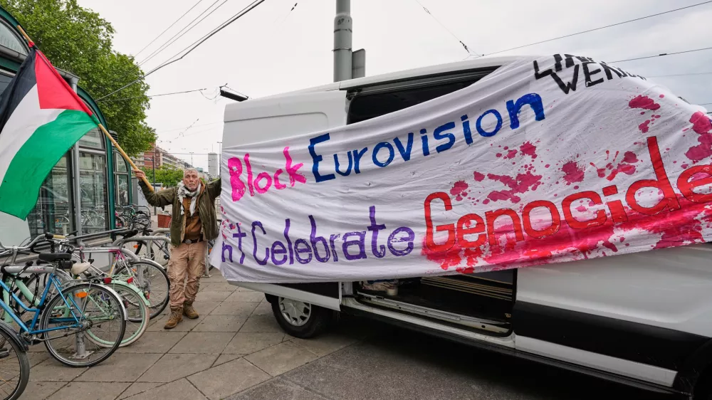 A man waves a Palestinian flag to protest against Israel ahead of the first semi-final of the 70th Eurovision Song Contest in Vienna, Austria, Tuesday, May 12, 2026. (AP Photo/Martin Meissner)