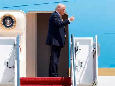 President Donald Trump gestures from the stairs of Air Force One as he boards upon his arrival at Joint Base Andrews, Md., Tuesday, May 12, 2026, for a trip to China to meet President Xi Jinping. (AP Photo/Luis M. Alvarez)