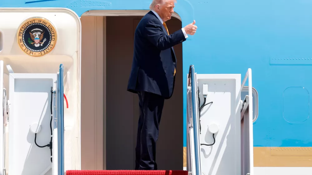 President Donald Trump gestures from the stairs of Air Force One as he boards upon his arrival at Joint Base Andrews, Md., Tuesday, May 12, 2026, for a trip to China to meet President Xi Jinping. (AP Photo/Luis M. Alvarez)