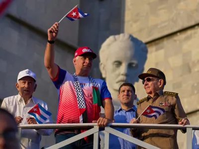 FILE - Cuba's President Miguel Diaz-Canel holds up a Cuban flag as he watches the May Day parade next to Raul Castro, second from right, and Raul Castro's grandson, Raul Guillermo Rodriguez Castro, at Revolution Square in Havana, May 1, 2025. (AP Photo/Ramon Espinosa, File)