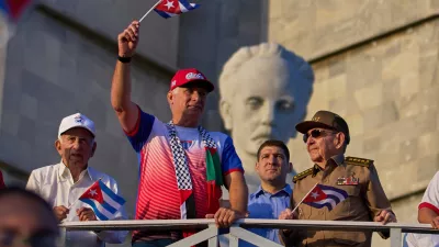 FILE - Cuba's President Miguel Diaz-Canel holds up a Cuban flag as he watches the May Day parade next to Raul Castro, second from right, and Raul Castro's grandson, Raul Guillermo Rodriguez Castro, at Revolution Square in Havana, May 1, 2025. (AP Photo/Ramon Espinosa, File)