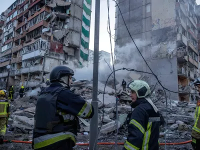 Rescuers work at the site of an apartment building that was damaged and partially collapsed during Russian missile and drone strikes, amid Russia's attack on Ukraine, in Kyiv, Ukraine May 14, 2026. REUTERS/Thomas Peter    TPX IMAGES OF THE DAY