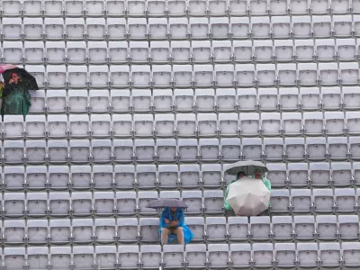 Spectators shelter with umbrellas as the quarter-final match between Karen Khachanov, of Russia, and Casper Ruud, of Norway, is suspended due to rain at the Italian Open tennis tournament in Rome, Wednesday, May 13, 2026. (AP Photo/Gregorio Borgia) / Foto: Gregorio Borgia