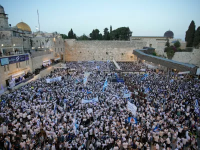Israelis wave national flags during a march marking Jerusalem Day, an Israeli holiday celebrating the capture of east Jerusalem in the 1967 Mideast war, next to the Western Wall in the Old City of Jerusalem, Thursday, May 14, 2026. (AP Photo/Ohad Zwigenberg)