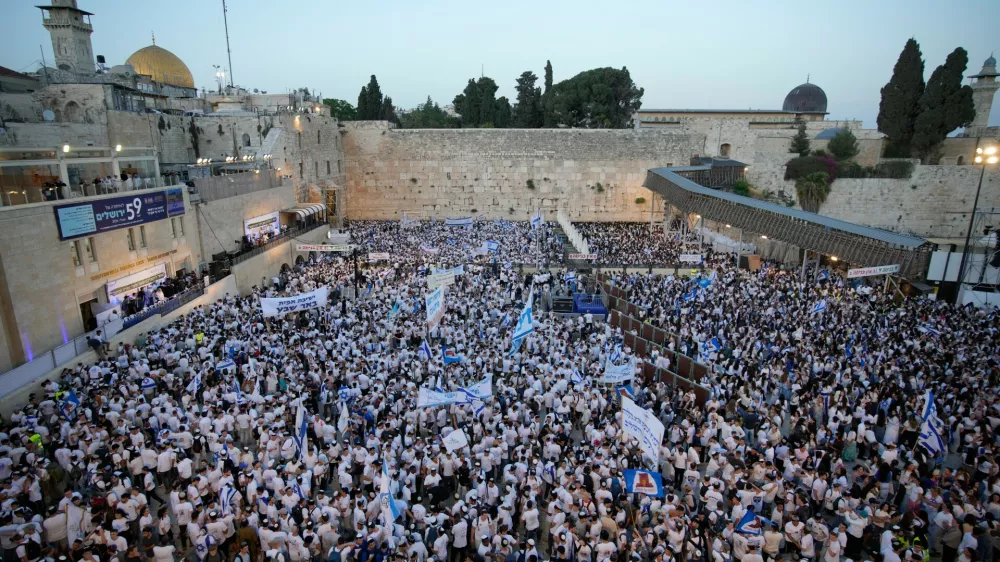 Israelis wave national flags during a march marking Jerusalem Day, an Israeli holiday celebrating the capture of east Jerusalem in the 1967 Mideast war, next to the Western Wall in the Old City of Jerusalem, Thursday, May 14, 2026. (AP Photo/Ohad Zwigenberg)