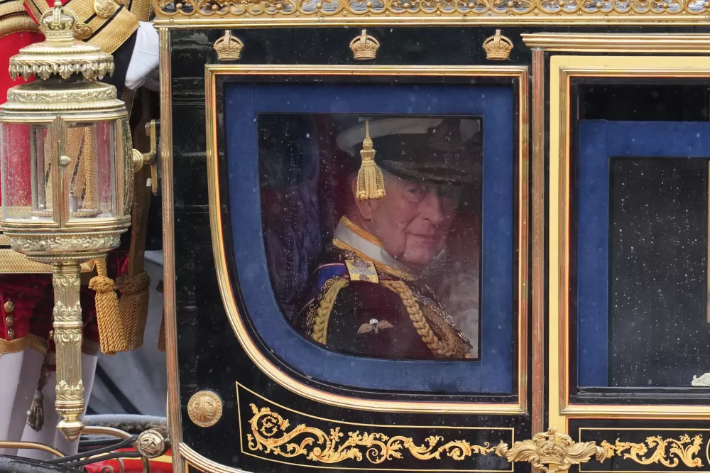 Britain's King Charles III beside Queen Camilla leaves Buckingham Palace in the State Coach to attend the State Opening of Parliament at the Palace of Westminster in London, Wednesday, May 13, 2026.(AP Photo/Kin Cheung)