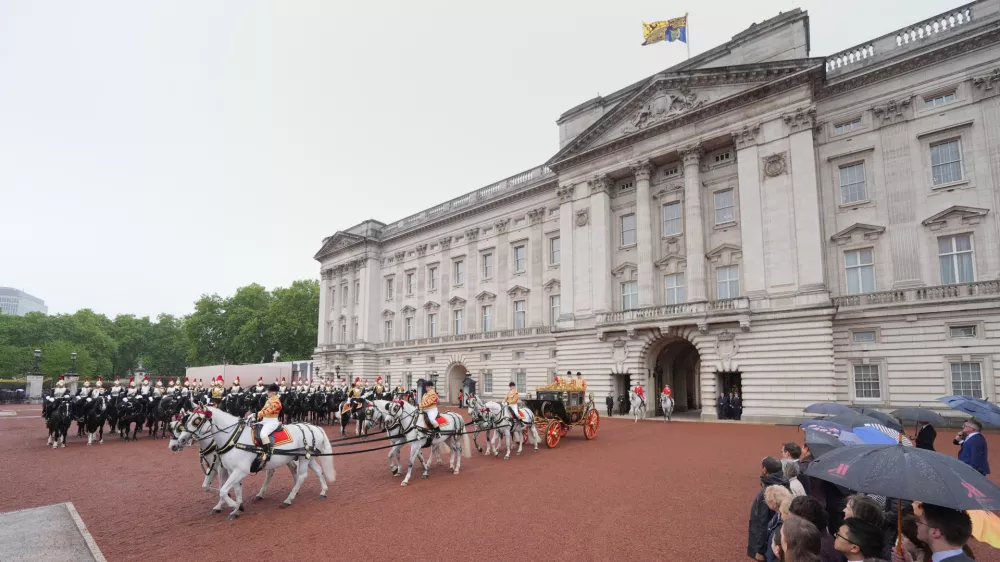 Britain's King Charles III and Queen Camilla travel in the Irish State Coach as they depart Buckingham Palace, London, to attend the State Opening of Parliament in the House of Lords, in London, Wednesday May 13, 2026. (Yui Mok/Pool Photo via AP)