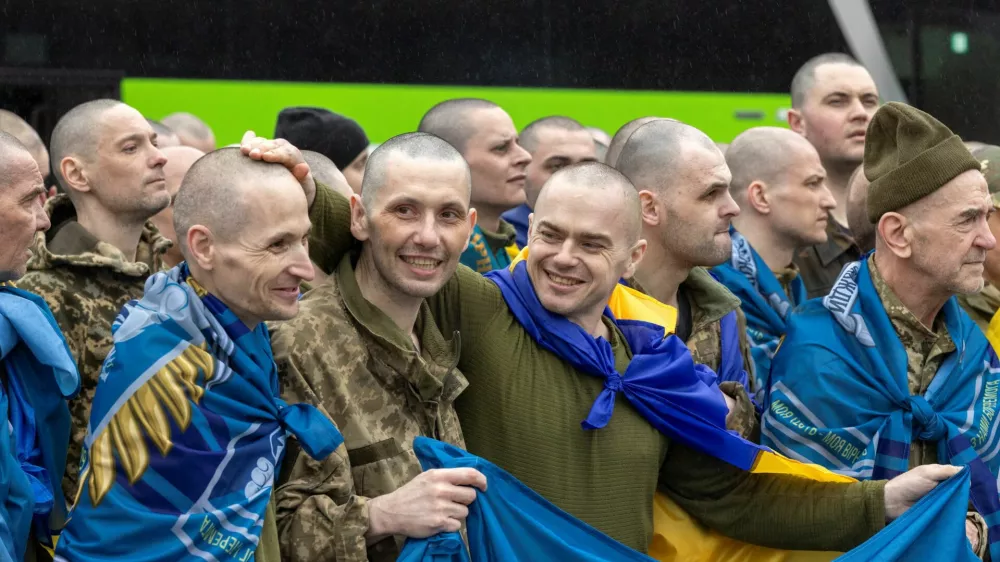 Ukrainian servicemen and former prisoners of war (POW) react after they set foot on Ukrainian soil after a POW swap with Russia, amid Russia's attack on Ukraine, at an undisclosed location in Ukraine May 15, 2026. REUTERS/Thomas Peter