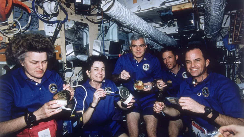 March 1996: NASA's STS-76 Atlantis Space Shuttle crew enjoying a meal aboard Russia's MIR Space Station. Their mission is part of the first phase of the International Space Program combining multinational efforts in a quest to establish a permanently-manned orbiting space laboratory. From left - mission specialists Shannon Lucid, Linda Godwin, and Michael Clifford, Pilot Richard Searfoss and commander Kevin Chilton. (Photo by Space Frontiers/Space Frontiers/Getty Images)